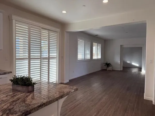 a view of a kitchen with wooden floor and a window