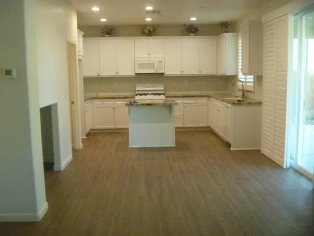 a kitchen with white cabinets and white appliances