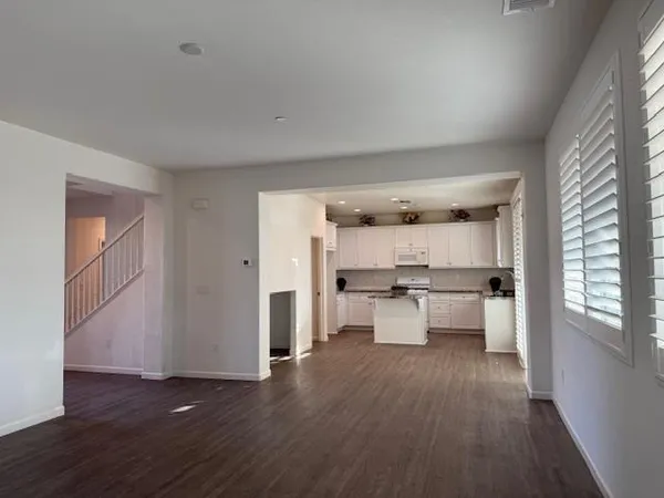 a kitchen with granite countertop white cabinets and white appliances