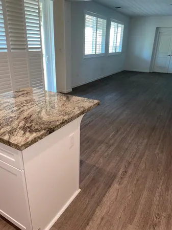 a kitchen with granite countertop white cabinets and a sink
