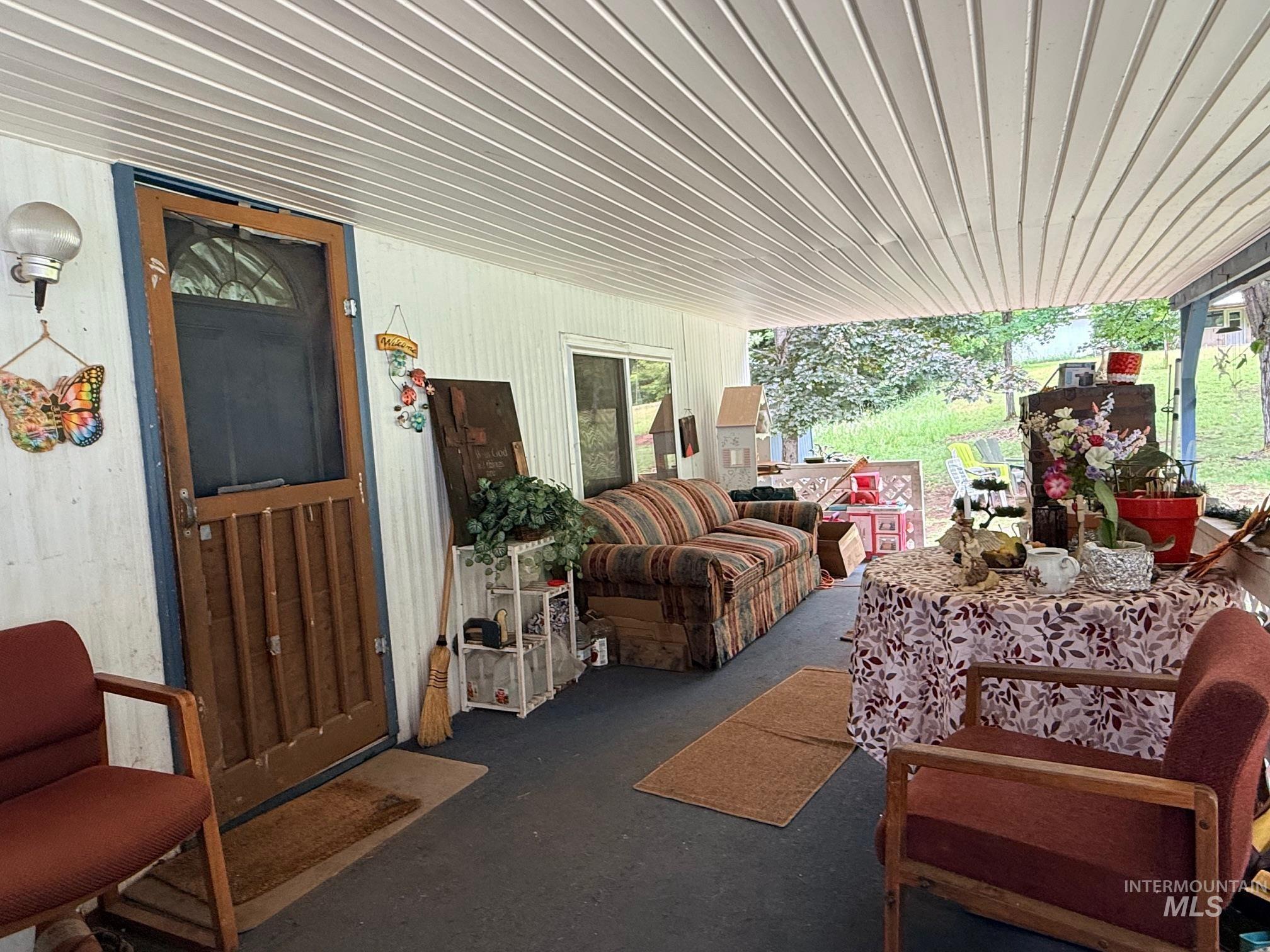 5742 Grangemont Road Orofino, ID 83544 - Photo 3 of 25 Covered porch area featuring a slatted ceiling and wood-finish door with an arched glass panel