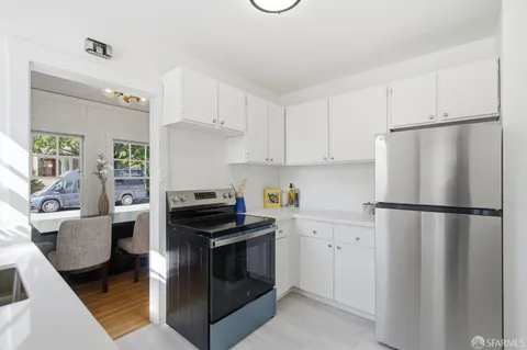 a kitchen with a refrigerator stove and white cabinets