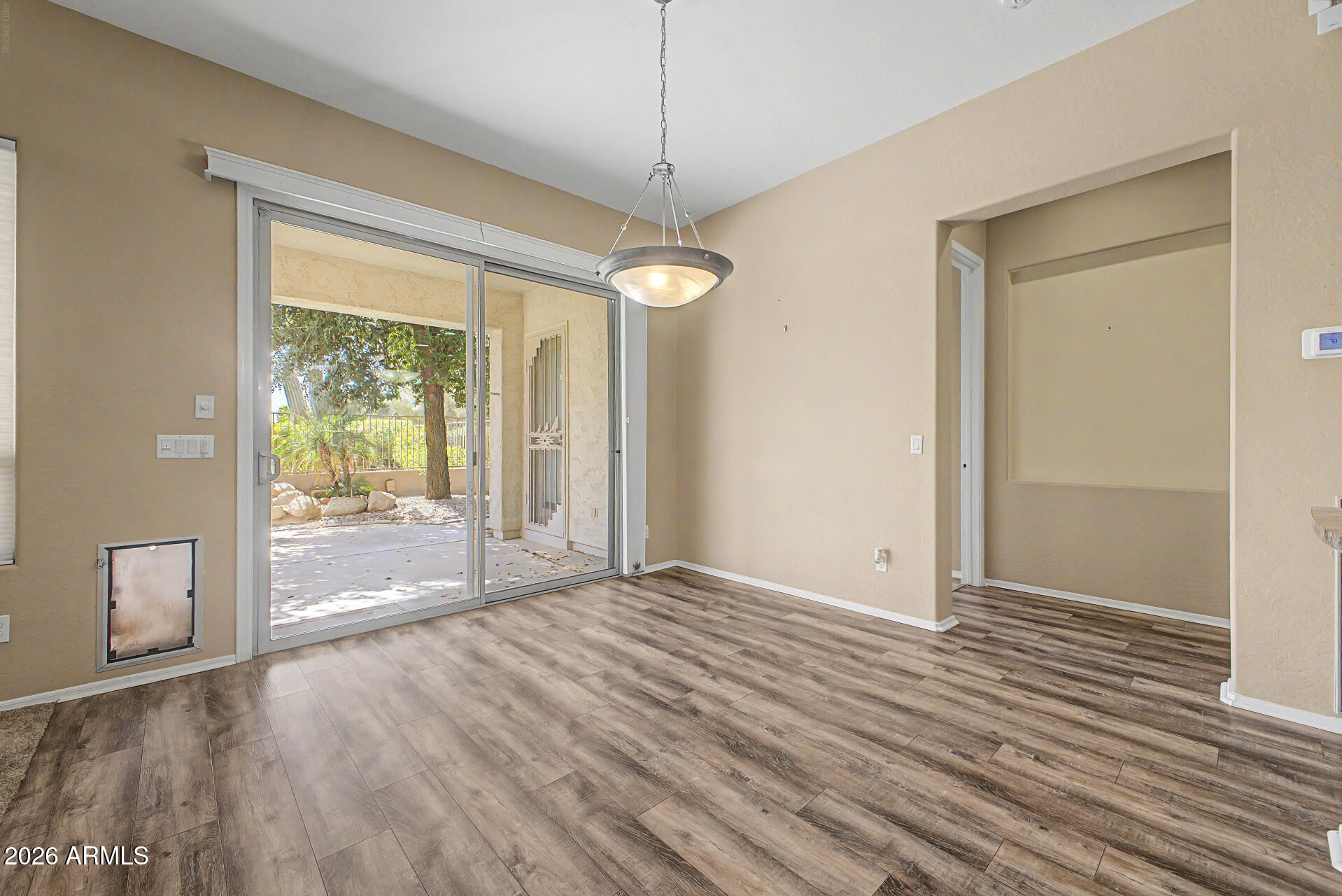 5090 South Ranger Trail Gilbert, AZ 85298 - Photo 8 of 50 a view of an empty room with wooden floor and a window