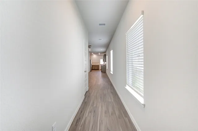 a view of a hallway with wooden floor and staircase