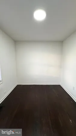 an empty room with a wooden floor and a window