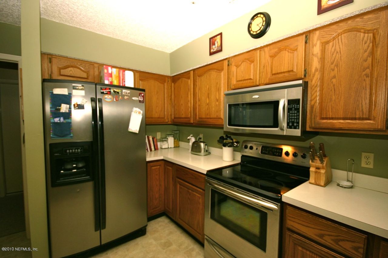 3125 Nautilus Road Middleburg, FL 32068 - Photo 6 of 23 a kitchen with stainless steel appliances a stove a microwave and a sink
