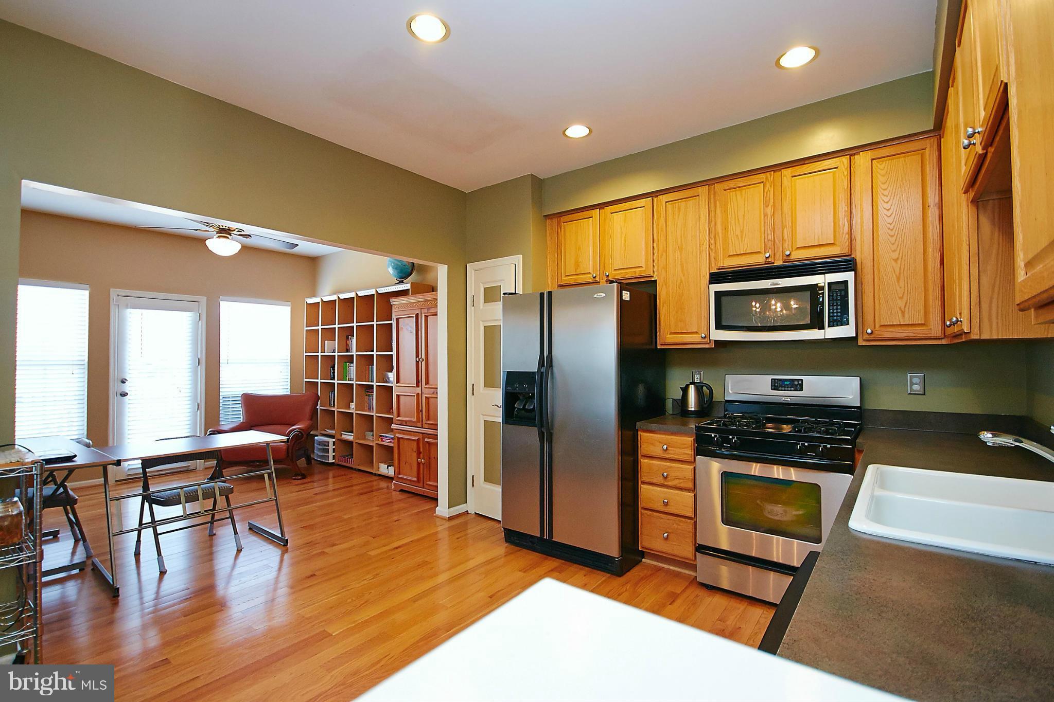 9639 Innerwick Place Bristow, VA 20136 - Photo 10 of 29 a kitchen with stainless steel appliances granite countertop a refrigerator stove top oven dining table and chairs