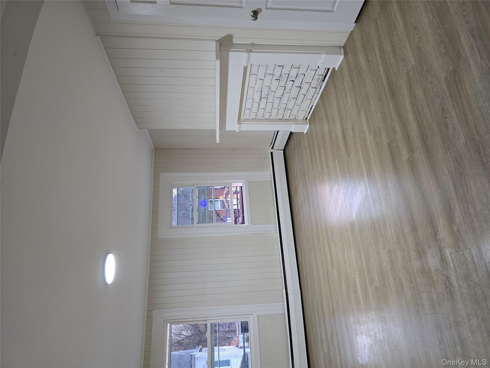 185 Mill Street Poughkeepsie, NY 12601 - Photo 15 of 26 an empty room with wooden floor and windows