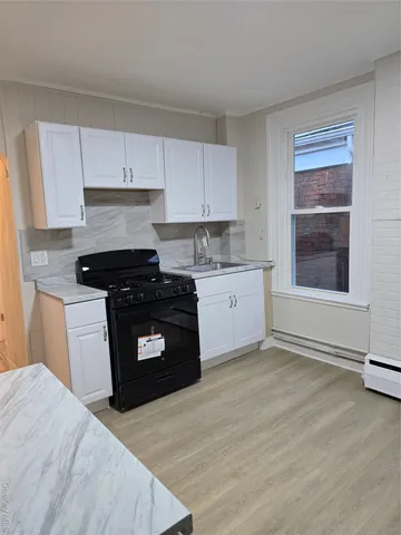a kitchen with a stove a sink and a window