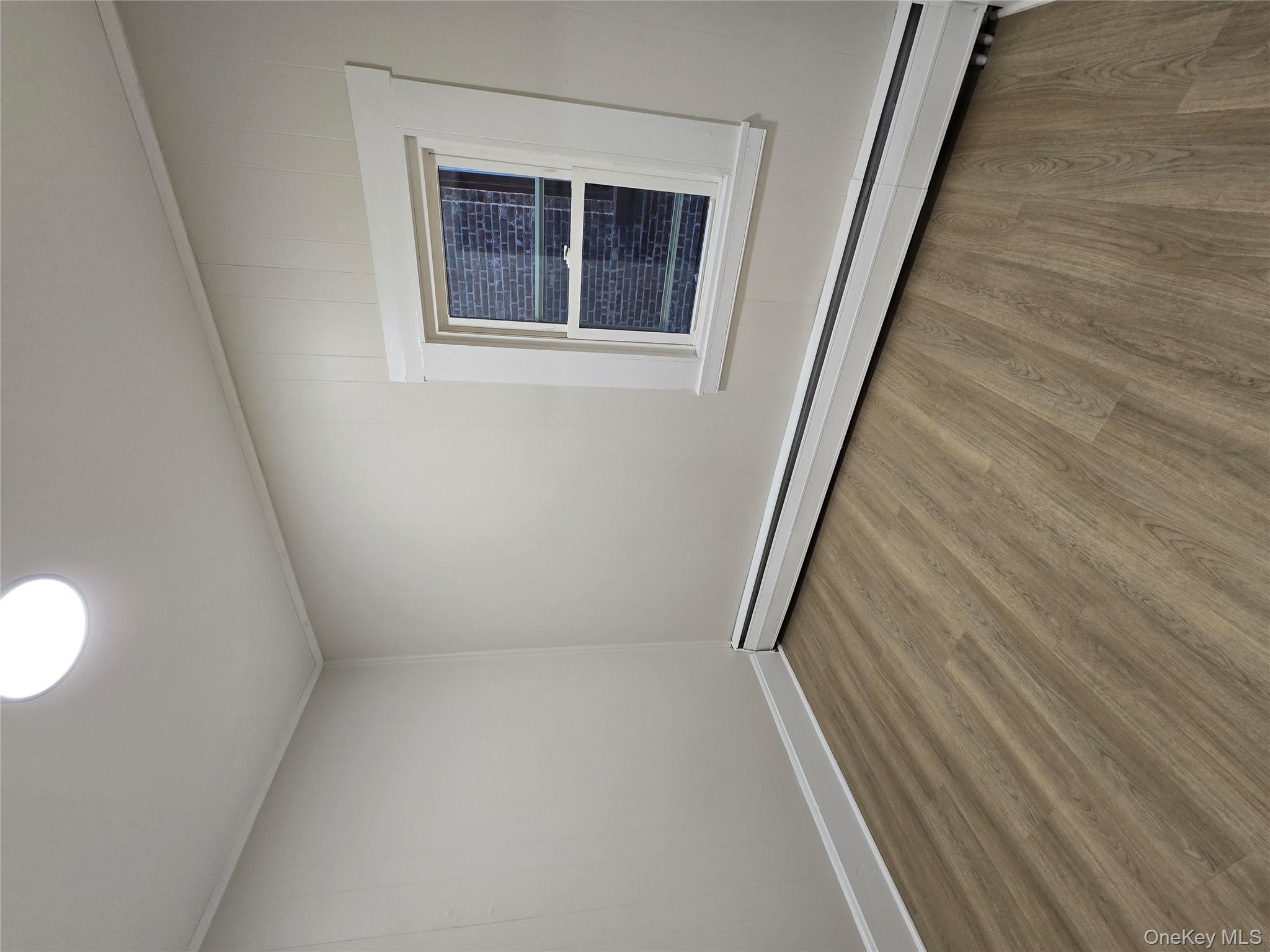 185 Mill Street Poughkeepsie, NY 12601 - Photo 4 of 26 a view of an empty room with wooden floor and a window