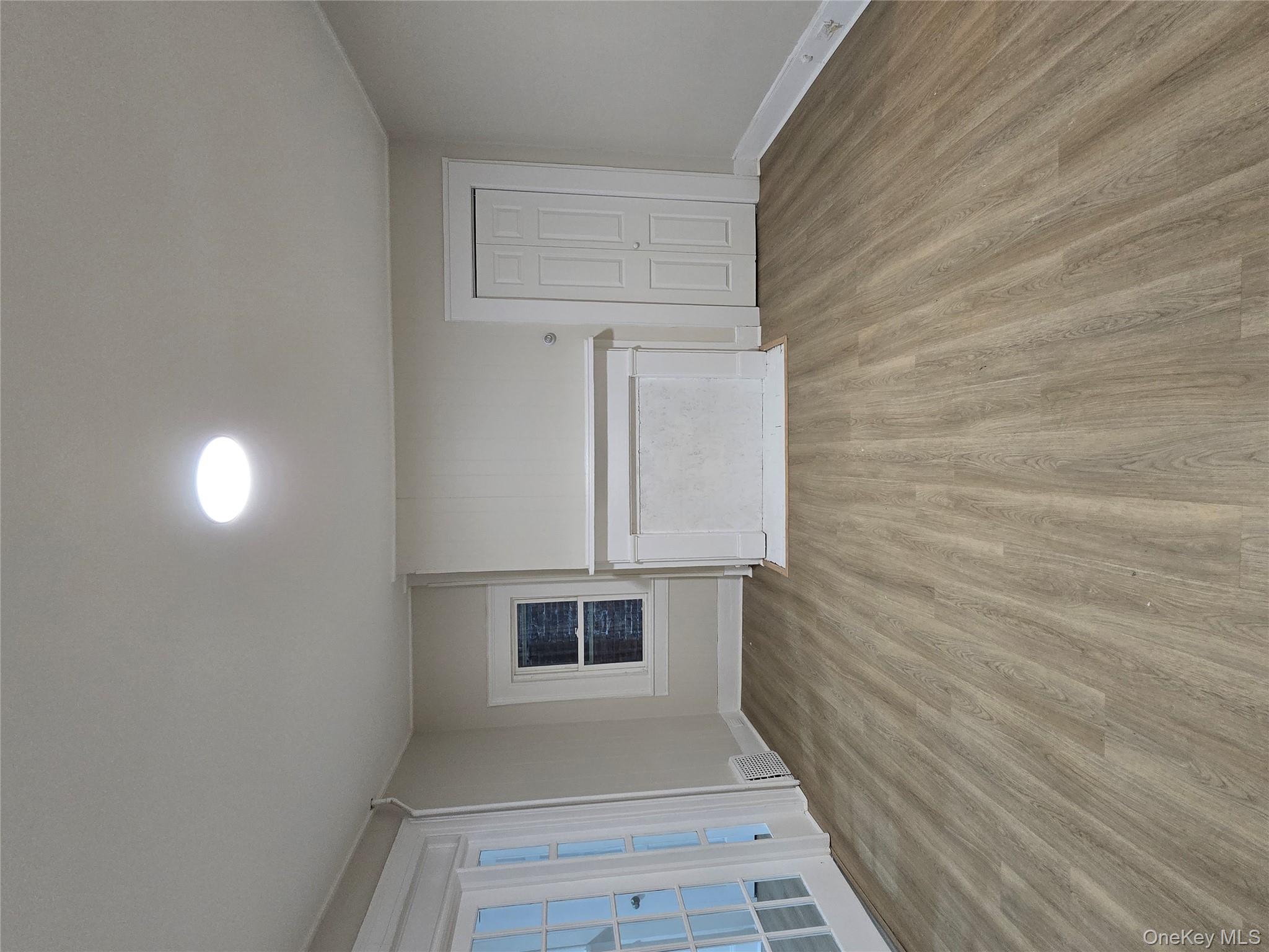 185 Mill Street Poughkeepsie, NY 12601 - Photo 5 of 26 a view of an empty room with wooden floor and a window