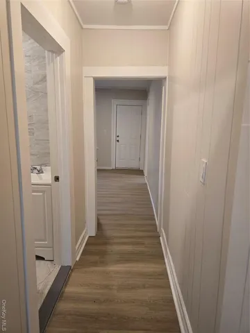 a view of a hallway with wooden floor and staircase