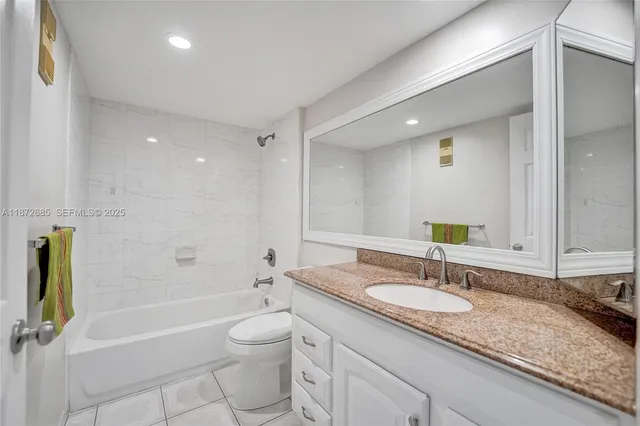 a bathroom with a granite countertop sink a toilet and bathtub