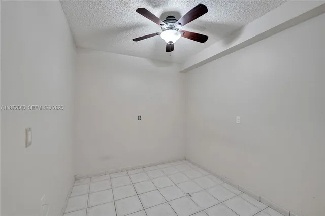 an empty room with a ceiling fan and carpet