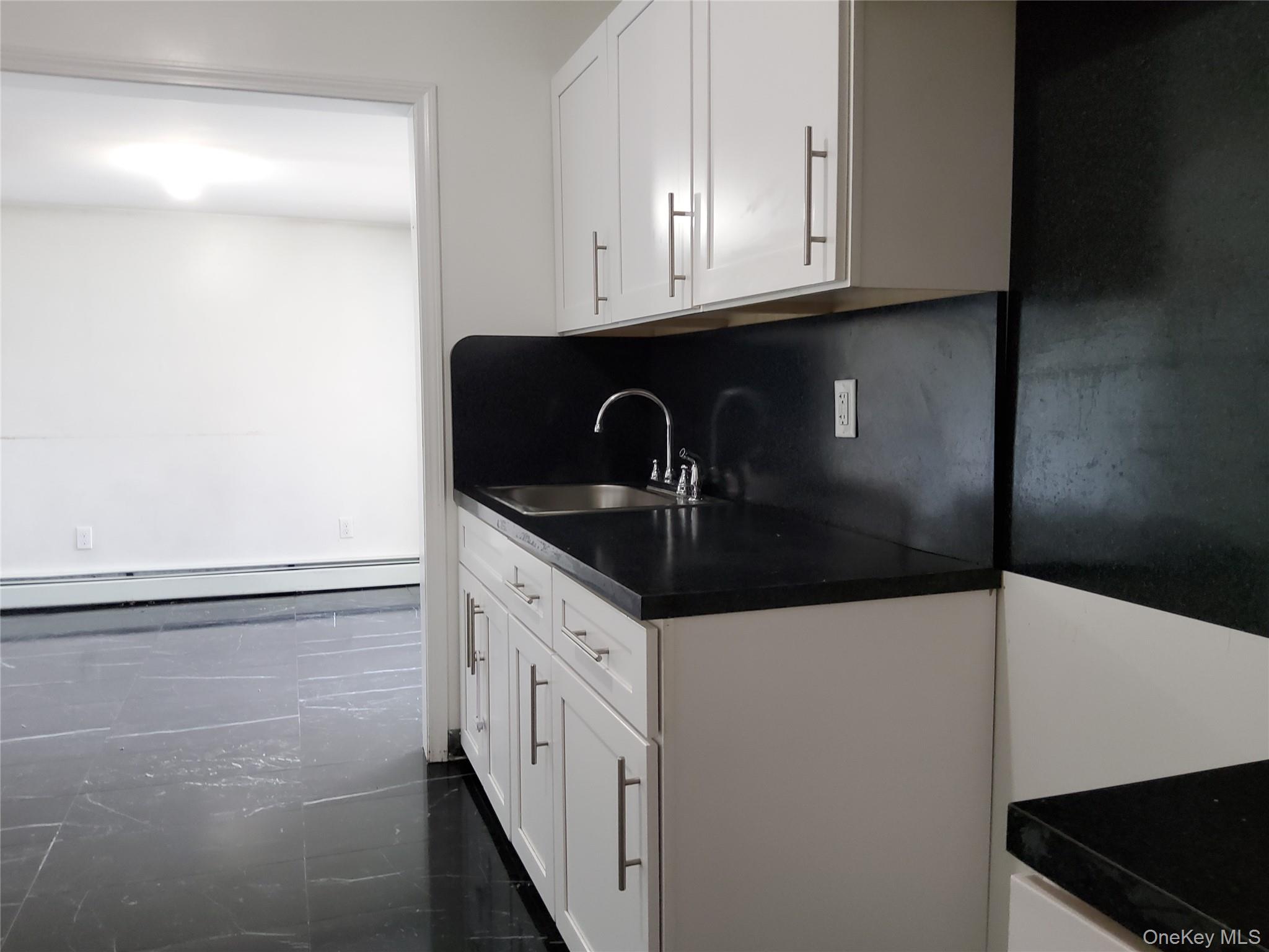469 Hillside Road Monroe, NY 10950 - Photo 3 of 20 a kitchen with granite countertop white cabinets and black appliances