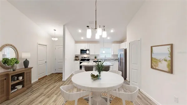 a dining room with furniture a kitchen a chandelier and wooden floor