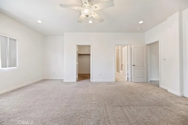 an empty room with fan and windows