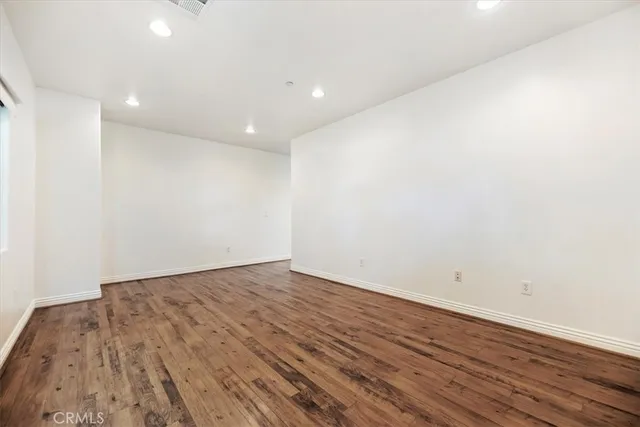 a view of room with wooden floor and white walls