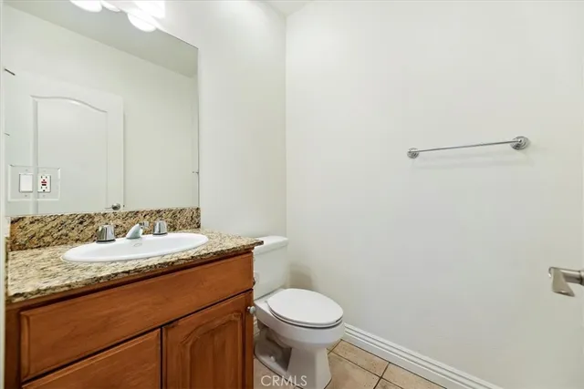 a bathroom with a granite countertop sink toilet and a mirror