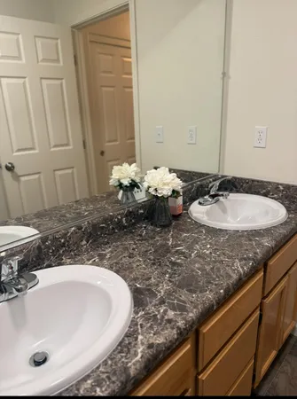 a bathroom with a granite countertop sink and a mirror
