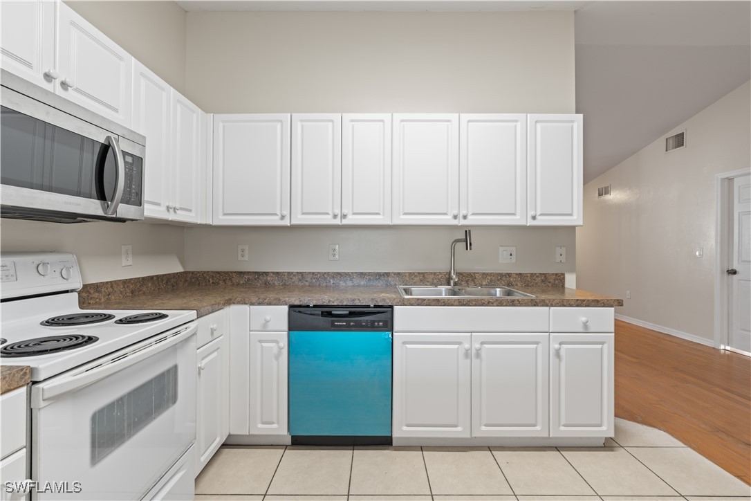 209 Meadow Road Lehigh Acres, FL 33973 - Photo 3 of 48 a kitchen with granite countertop white cabinets and white appliances