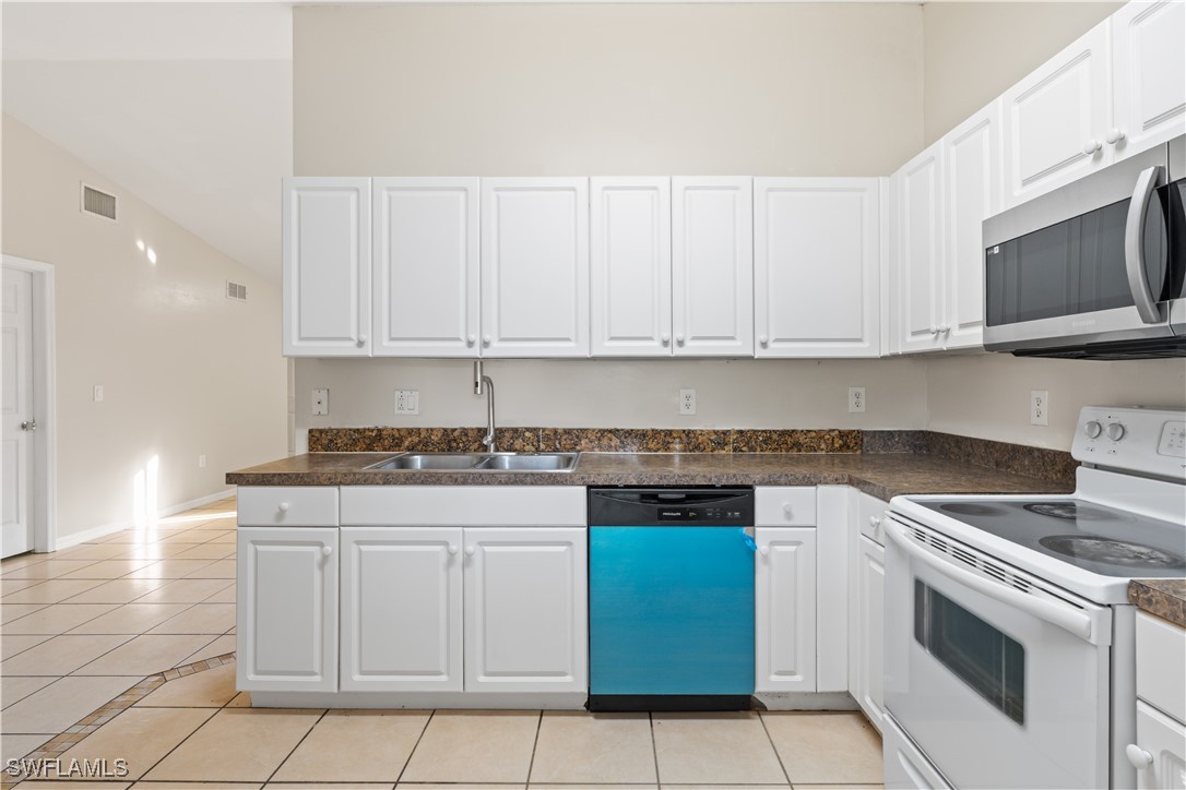 209 Meadow Road Lehigh Acres, FL 33973 - Photo 36 of 48 a kitchen with cabinets appliances and a sink