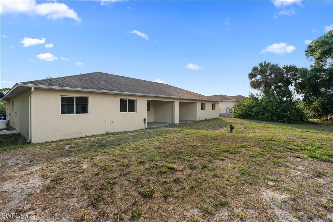 209 Meadow Road Lehigh Acres, FL 33973 - Photo 44 of 48 a view of a house with a backyard