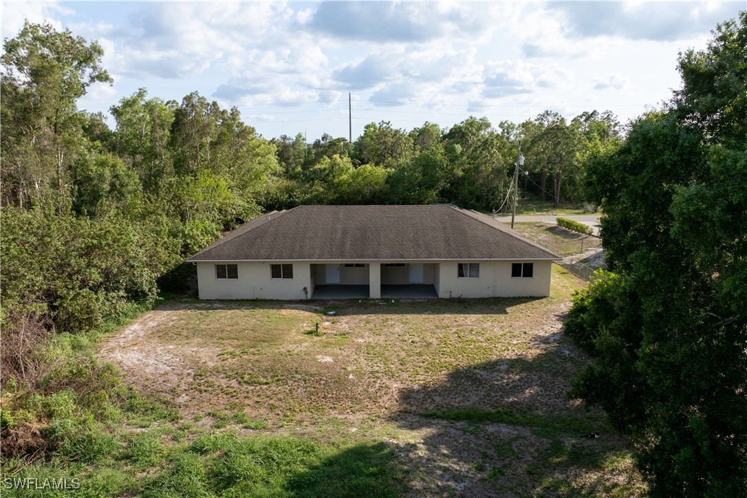 209 Meadow Road Lehigh Acres, FL 33973 - Photo 46 of 48 a house with trees in the background
