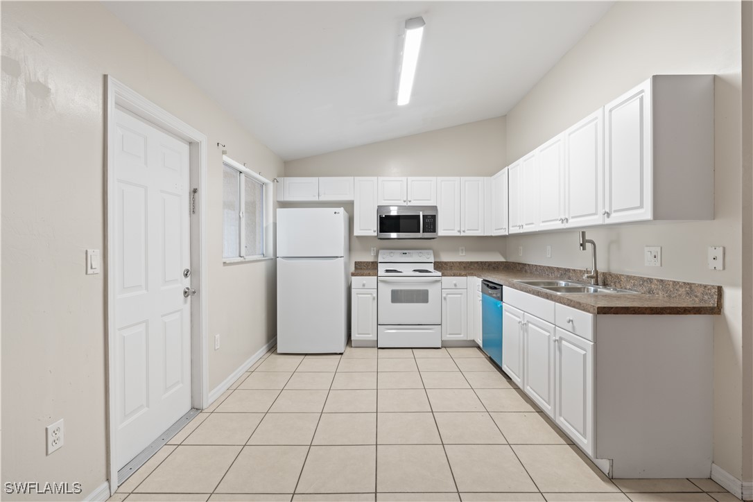 209 Meadow Road Lehigh Acres, FL 33973 - Photo 5 of 48 a kitchen with cabinets and white appliances