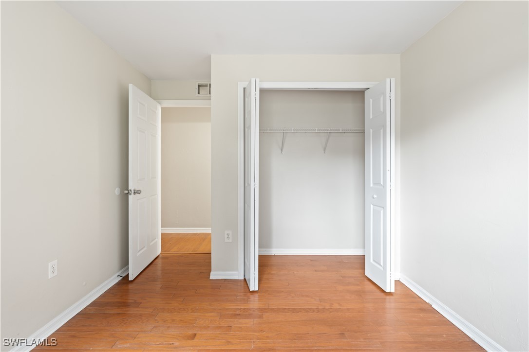 209 Meadow Road Lehigh Acres, FL 33973 - Photo 7 of 48 a view of an empty room with wooden floor and closet