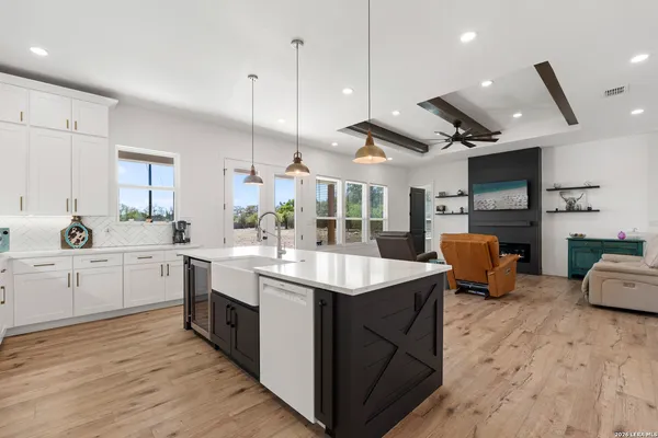 a large kitchen with stainless steel appliances kitchen island granite countertop a sink counter space and wooden floors