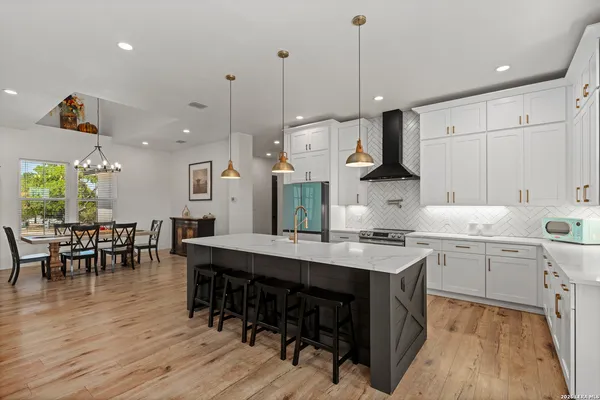 a kitchen with a table chairs sink and cabinets