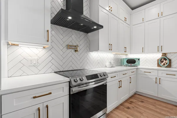 a kitchen with granite countertop white cabinets and white appliances