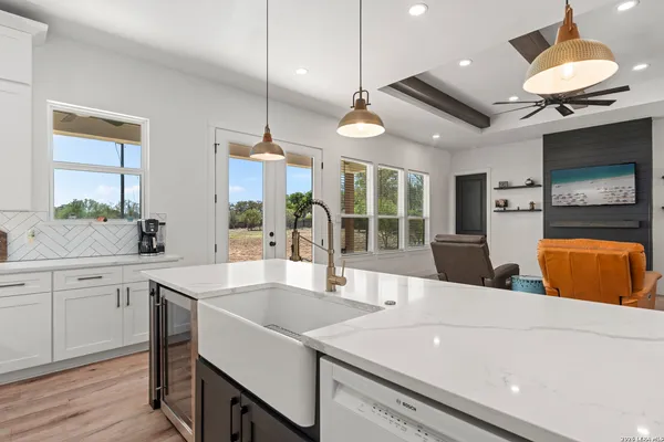 a large kitchen with kitchen island a counter space a sink stainless steel appliances and cabinets