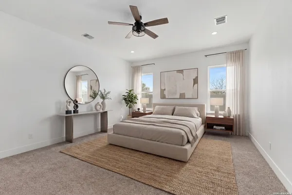 a spacious bedroom with a bed a dresser and potted plant