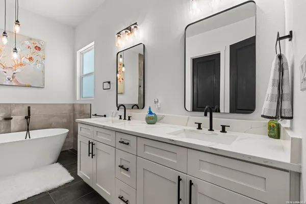 a bathroom with double sink and a mirror
