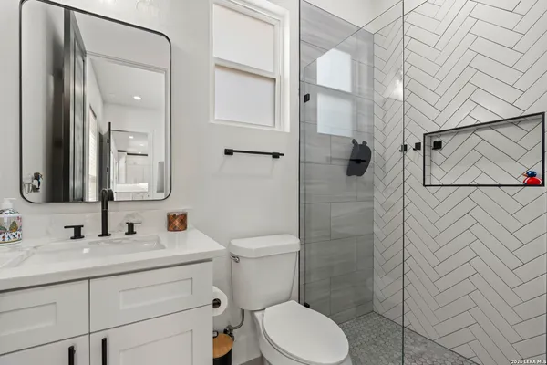 a bathroom with a sink a toilet and shower
