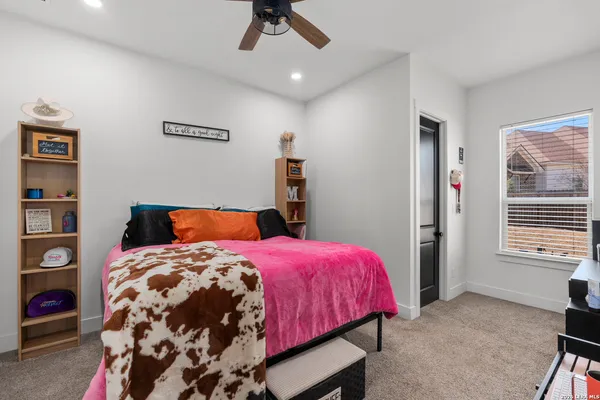 a bedroom with a bed a dresser and a window