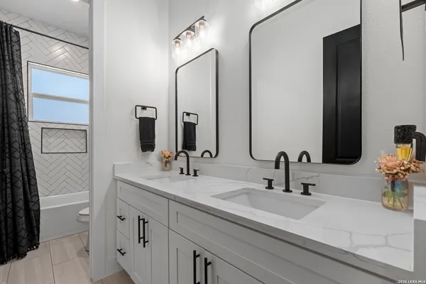 a bathroom with double vanity sink and two mirror