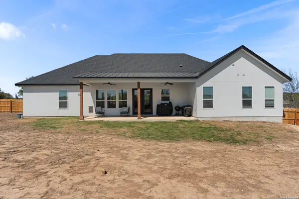 a view of a house with a yard and large tree