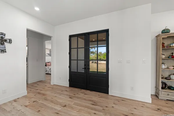 a view of an empty room with wooden floor and closet