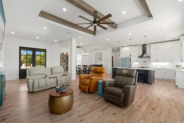 a living room with furniture kitchen view and a chandelier