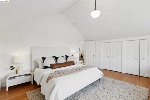 a bedroom with a bed wooden floor and a table