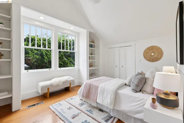a view of a backyard with table and chairs potted plants and large tree