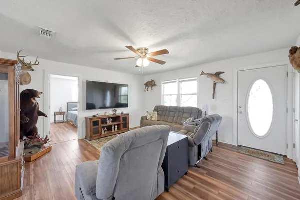 a dining room with wooden floor a chandelier a wooden table and chairs