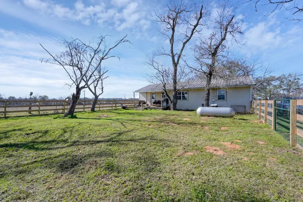 a view of a house with backyard and tree