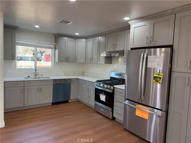 a kitchen with stainless steel appliances granite countertop a refrigerator sink and stove