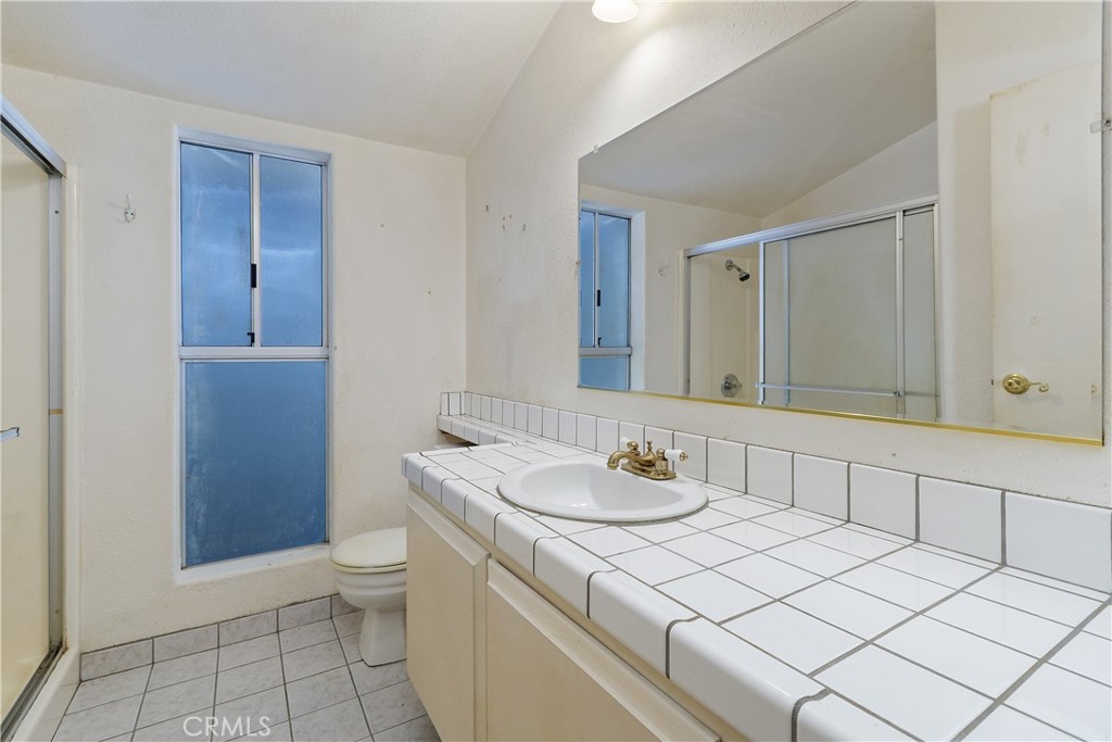 34881 Los Nogales Road Temecula, CA 92592 - Photo 38 of 50 Hall bath with walk-in shower, tile counter and tile flooring.