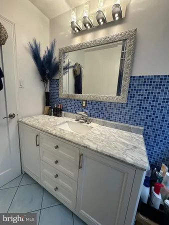 a bathroom with a granite countertop sink a mirror and vanity