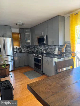 a kitchen with stainless steel appliances granite countertop a stove top oven a sink dishwasher and a refrigerator